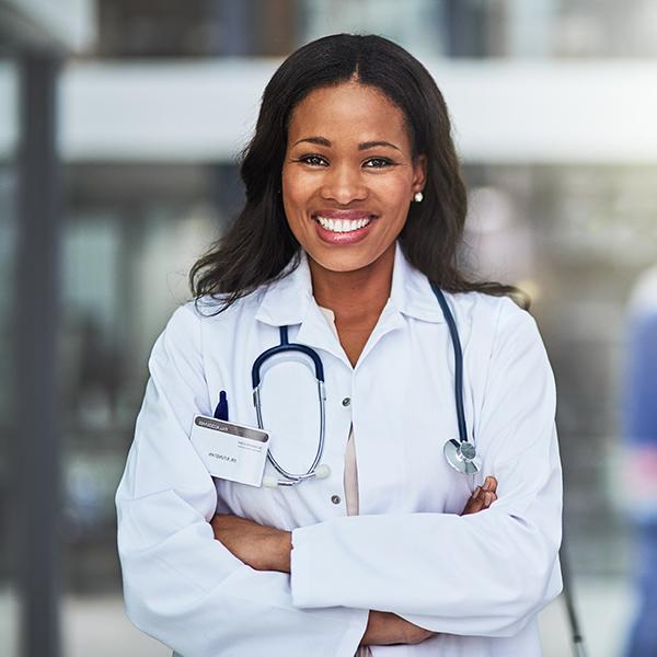 A smiling female medical professional standing in a hallway